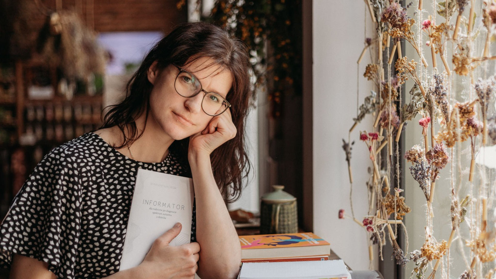 Agnieszka Sułkowska z Autyzm po ludzku. Stoi przy oknie, głowę podpiera ręką.